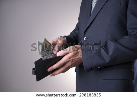 Businessman with money in studio on a gray background. Corruption concept