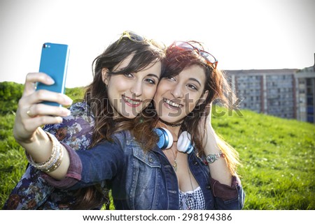 Two beautiful girls taking a selfie outdoor