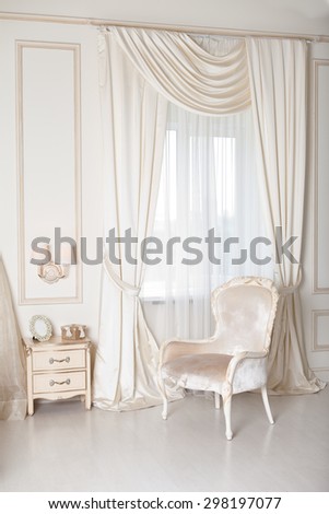Elegant arm-chair with near a window. Luxury interior in white colors. Armchair with velvet upholstery Royalty-Free Stock Photo #298197077