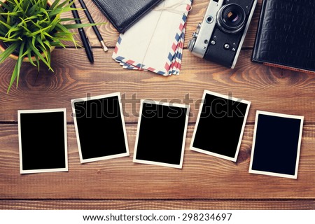 Blank photo frames, camera and supplies on wooden table. Top view. Toned