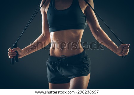Sport, activity. Cute woman with skipping rope. Muscular woman  black background. Royalty-Free Stock Photo #298238657