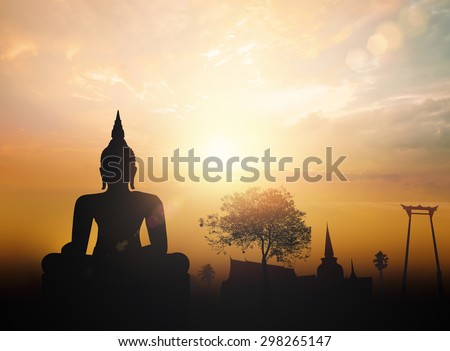Vesak day concept: Silhouette Buddha with blurred tourist attraction in thailand on golden sunset background. Royalty-Free Stock Photo #298265147