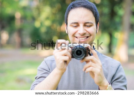 Portrait of a smiling man using a compact camera