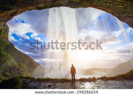 incredible waterfall in Iceland, silhouette of man enjoying amazing view of nature