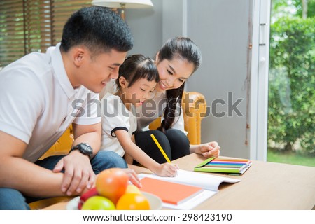 Father and mother Teaching children to do their homework at home