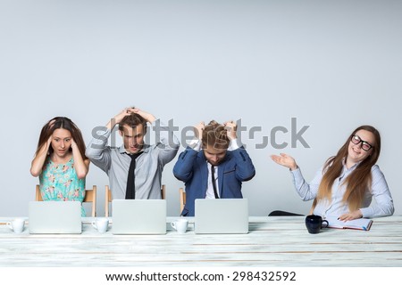 Business team working on their business project together at office on light gray background. all all grabbed his head. boss laughing. copyspace image. 