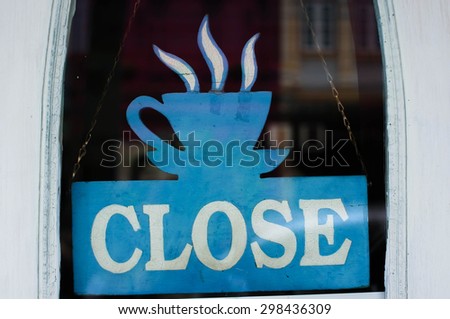 Close sign at coffee street cafe shot through a dirty diner window