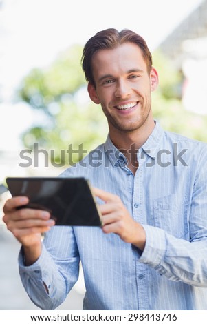 Portrait of a handsome smiling man holding a tablet