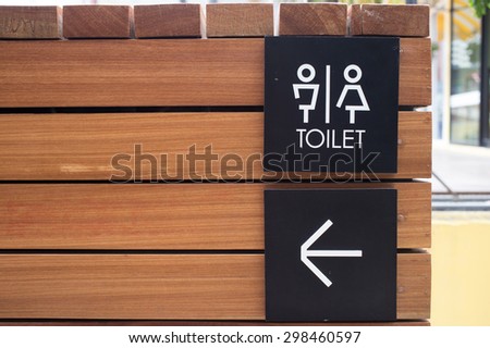 Toilet Sign on wooden background.
