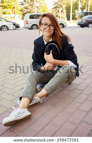 smiling girl hipster sitting on skateboard
