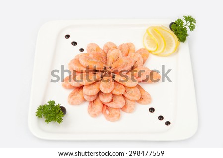 boiled shrimp with lemon on a white plate