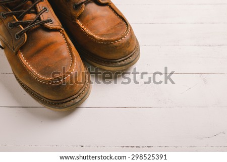 Old leather boot traditional leather style on wooden background with filter vintage style effect