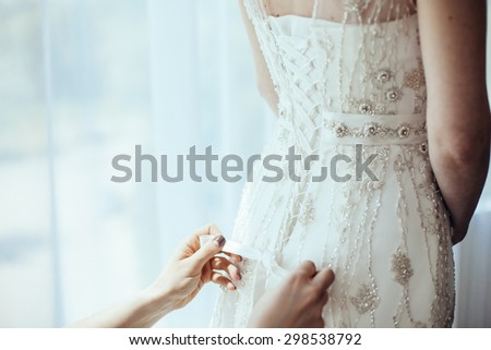 bridesmaid tying bow on wedding dress

 Royalty-Free Stock Photo #298538792