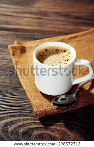 Cup of coffee on napkin on table close up