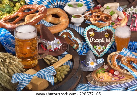 All typical German Bavarian symbols in one picture. Gingerbread heart with â??The beer is tappedâ?? text, soft pretzels, Bavarian veal sausage and beer. 