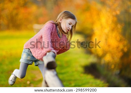 Portrait of a cute little girl on beautiful golden autumn day
