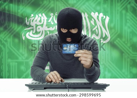 Dark-skinned hacker with credit card and flag on background - Saudi Arabia