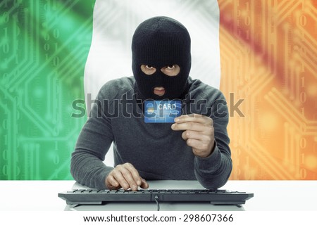 Dark-skinned hacker with credit card and flag on background - Ireland
