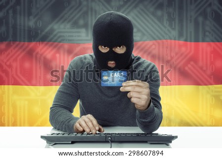 Dark-skinned hacker with credit card and flag on background - Germany