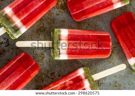 Close up of frozen fresh fruit watermelon and kiwi popsicles sitting on metal baking pan