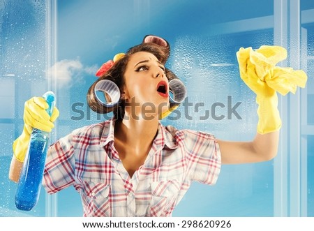 Pin-up housewife breathes on a clean glass Royalty-Free Stock Photo #298620926