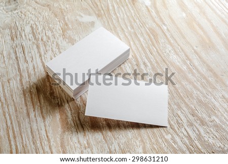 Photo of blank business cards on light wooden background. Mock-up for branding identity. 