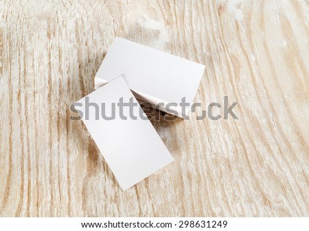 Blank business cards on light wooden background. Template for branding identity. Top view.