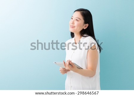 Beautiful young asian woman using tablet computer