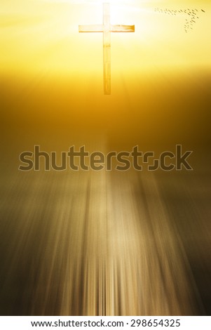 soft focus silhouette of cross on sunset background with light effect