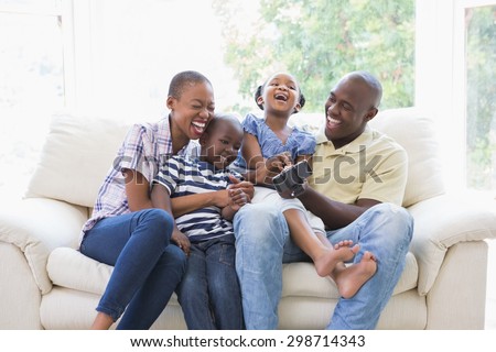 Happy smiling family on the couch in the living room. Social distancing and self isolation in quarantine lockdown for Coronavirus Covid19
 Royalty-Free Stock Photo #298714343