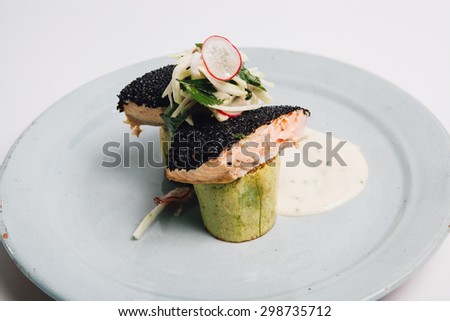 dish with grilled fish over zucchini and souce