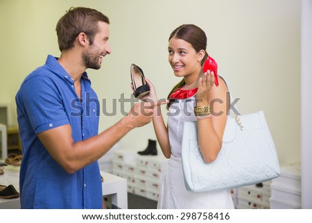 Young couple deciding on which shoe to choose in the shoe store