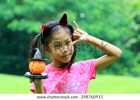 Close up portrait of Asian girl hold pumpkin doll in hand with garden background
