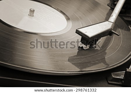 Record player stylus on a rotating disc, Picture of a vinyl record playing. Old Sepia film processed.