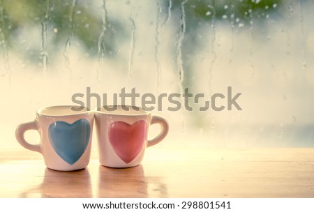 Two lovely glass on rainy day window background  in vintage color tone