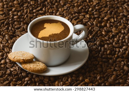 Still life photography of hot coffee beverage with map of Uganda