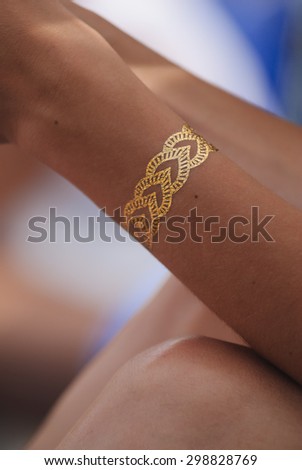 Temporary Metallic Flash Tattoo Bracelet on Woman's Arm Royalty-Free Stock Photo #298828769