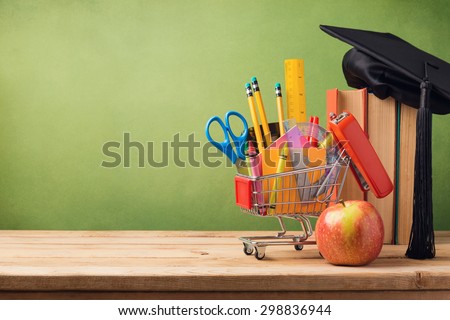 Back to school concept with shopping cart, books and graduation hat