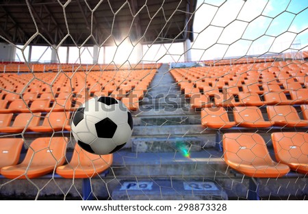 The symbolic power of success and a victory soccer ball (football) going into the in-goal net after shot in the game have a stadiums amphitheater empty seats of football’s fans for cheer football.