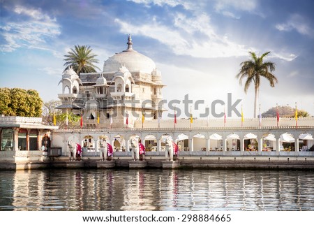 Luxury hotel on the Pichola lake at blue cloudy sky in Udaipur, Rajasthan, India Royalty-Free Stock Photo #298884665
