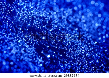 Closeup of fresh clean water drops on blue background