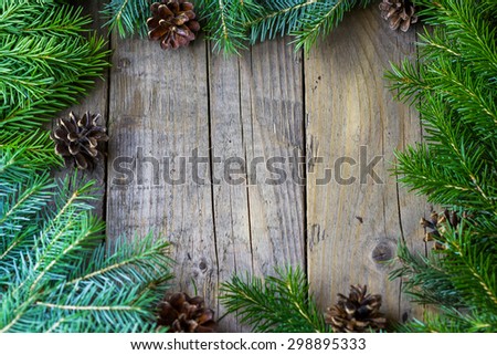 Christmas (New Year) decoration composition. Top view of fur-tree branches and cones frame on wooden background with place for your text