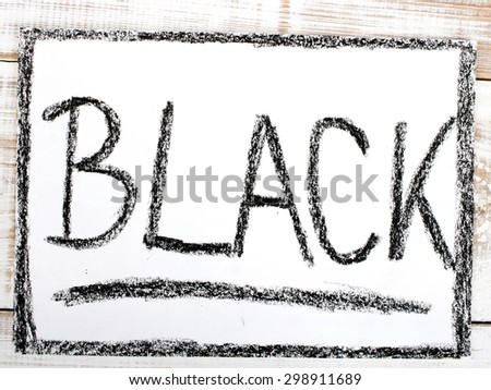 word BLACK written in black crayon on paper