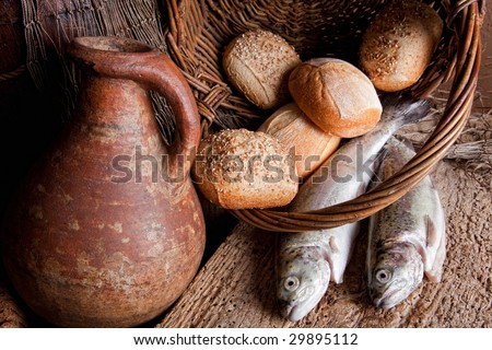 Wine, loaves of bread and fresh fish in an old basket Royalty-Free Stock Photo #29895112