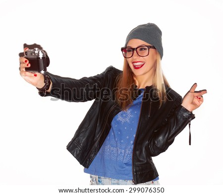 Pretty young stylish woman photographer posing outdoor with old vintage camera feels happy and smiling making photo selfi 
