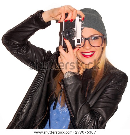 Pretty young stylish woman photographer posing outdoor with old vintage camera feels happy and smiling making photo selfi 