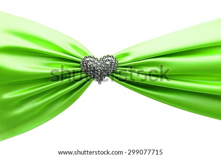 Shiny green satin ribbon and diamond heart on the white background.