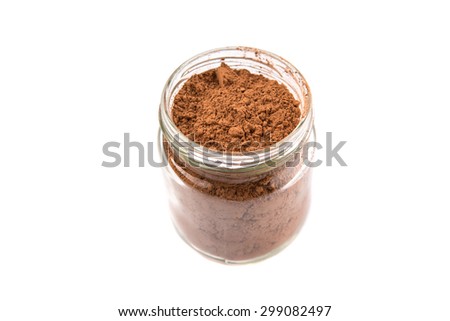 Brown pure cocoa powder in a mason jar over white background