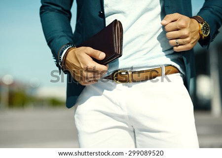 Fashion portrait of young businessman handsome  model man in casual cloth suit with accessories on hands Royalty-Free Stock Photo #299089520