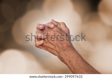 old woman hands praying to god for power on blurred sepia tone background concept.